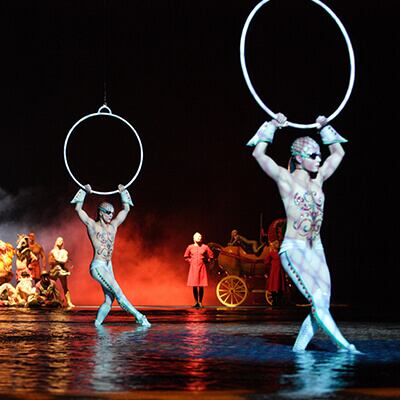 Acróbatas de aros aéreos bailan sobre el agua que cubre el escenario - O Cirque du Soleil Las Vegas