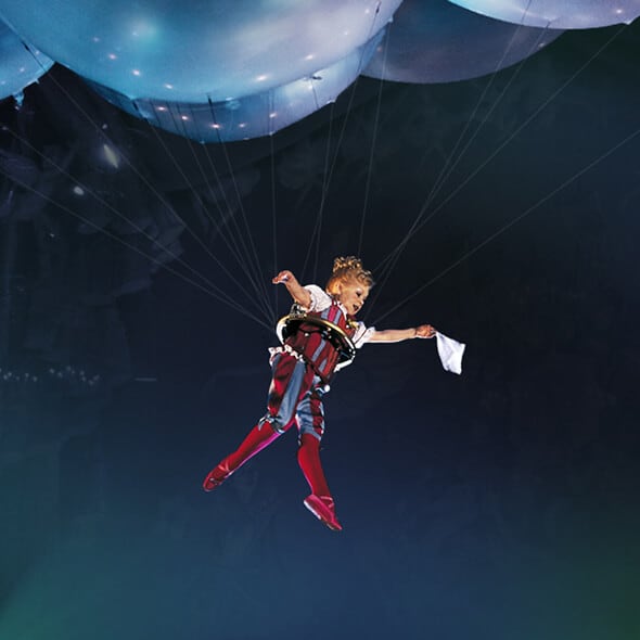 La clownesse tenue par des ballons descend du ciel - Cirque du Soleil Corteo