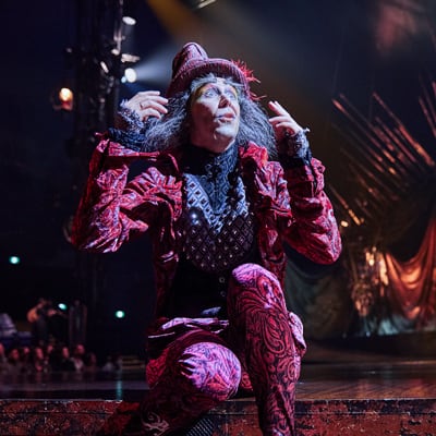 El tonto del viejo rey agachado al borde del escenario - Alegría Cirque du Soleil