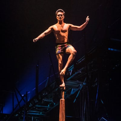 An artist stands in balance on an Indian pole (Mallakhamb) - Cirque du Soleil Bazzar