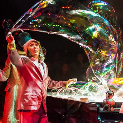 Two artists are making bubbles using soap coming out of a piano - Cirque du Soleil Love