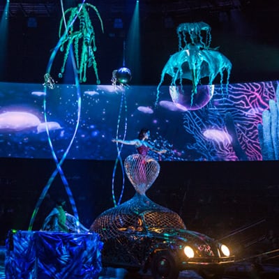 A visual creation representing aquatic animals fills the air in front of an underwater background - Beatles Cirque du Soleil