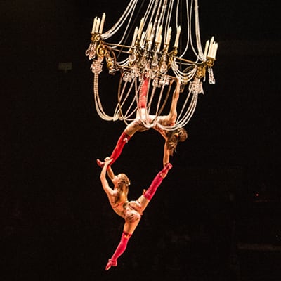 Performers dance suspended from a grandiose chandelier - Corteo