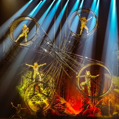 Four performers hang onto a round metallic spinning contraption named the Wheel of Death - Drawn to Life Cirque du Soleil.