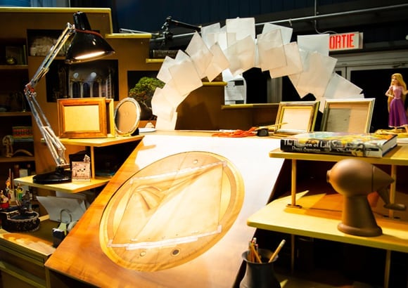 Una mesa de entretenimiento iluminada por una lámpara de escritorio negra - Drawn to Life Cirque du Soleil