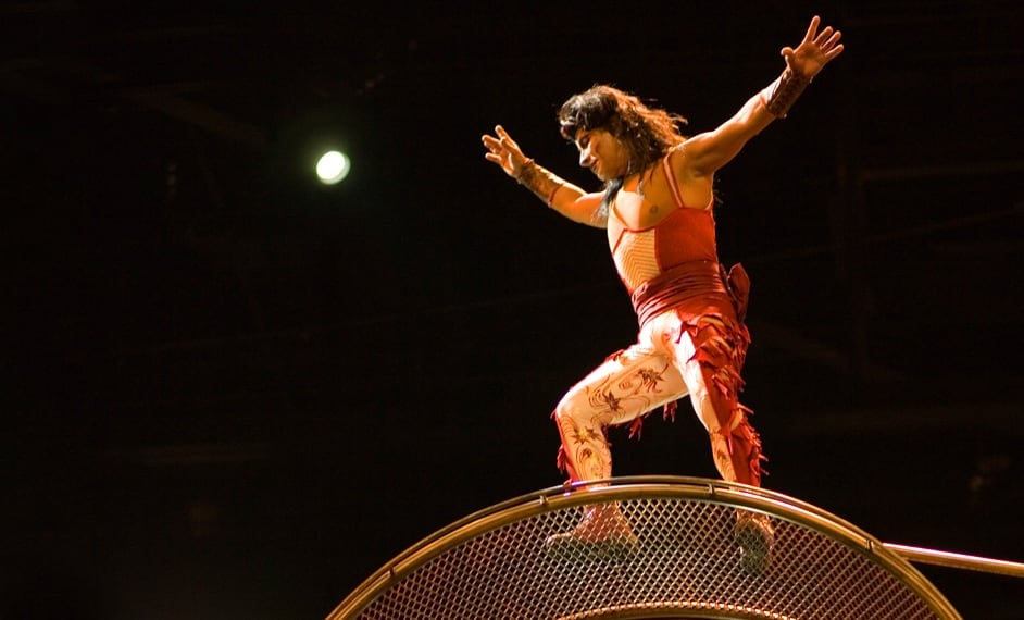 Man wearing a white and red costume balances over the wheel of death contraption - Kà Cirque du Soleil Las Vegas
