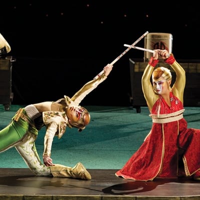 Dos artistas vestidos con ropa tradicional asiática luchan con espadas - Kà Cirque du Soleil