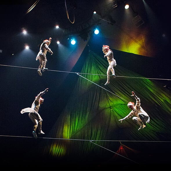 Four tightrope walkers are performing on a double highwire above the stage - Kooza Cirque du Soleil  