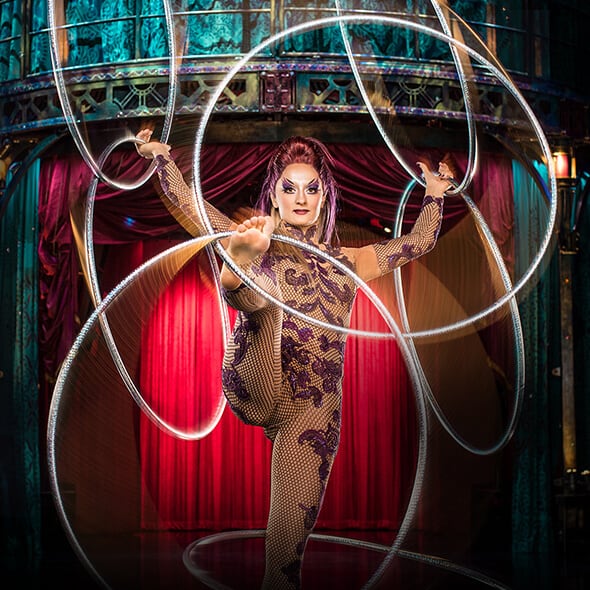 Artista femenina hace girar siete aros simultáneamente en su cuerpo - Kooza Cirque du Soleil