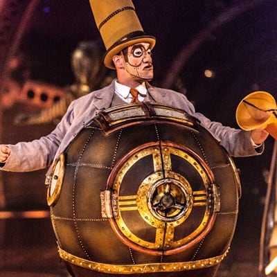 Man wears a metallic and round structure on his body that represents technological progress - Cirque du Soleil Kurios