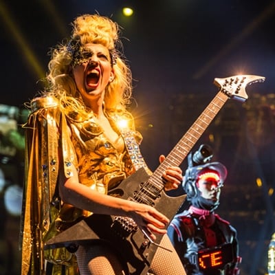 Un músico vestido de amarillo toca la guitarra eléctrica - espectáculo de Michael Jackson